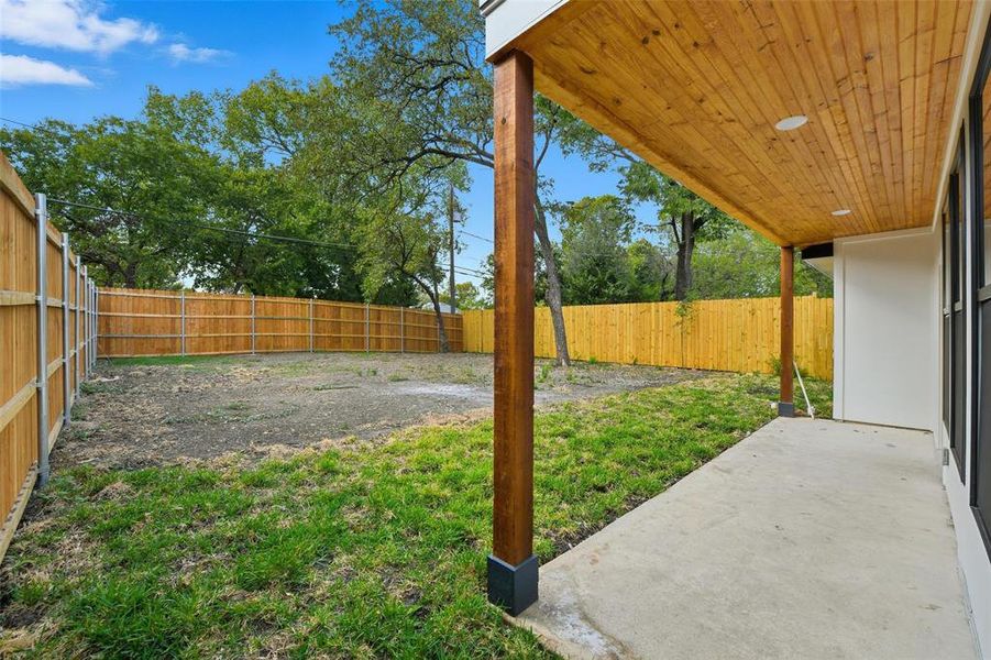 Fenced backyard with a patio