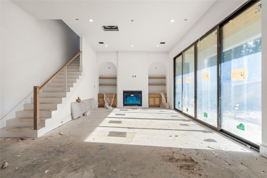Living room opens to the covered patio through these beautiful, oversized metal sliding doors. Gas fireplace with custom built shelving. Living room opens to the covered patio through these beautiful, oversized metal sliding doors. Gas fireplace with custom built shelving.
