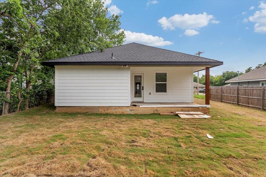 Back of house featuring back porch with a fenced in backyard