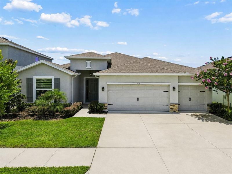 Front exterior of a new home in Deerbrook, Land O' Lakes, FL, highlighting curb appeal (Image 25).