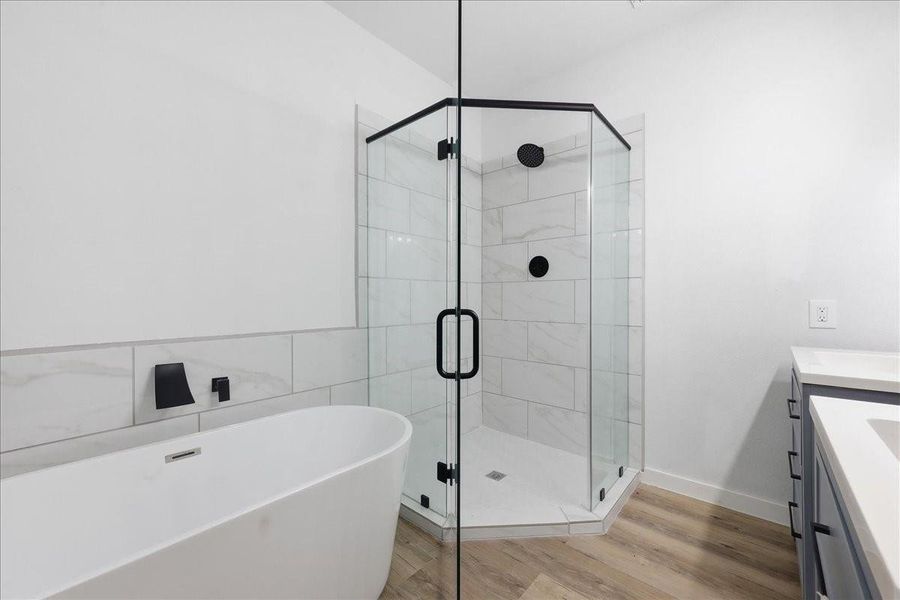 Spa-like primary bathroom showcases a freestanding soaking tub and a separate glass-enclosed shower. Spa-like primary bathroom showcases a freestanding soaking tub and a separate glass-enclosed shower.
