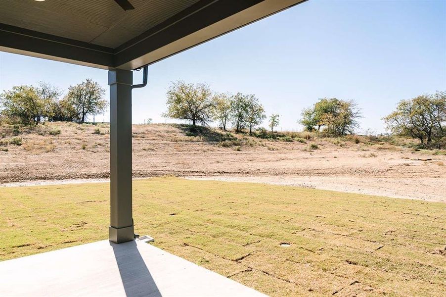 View of yard featuring ceiling fan and a patio