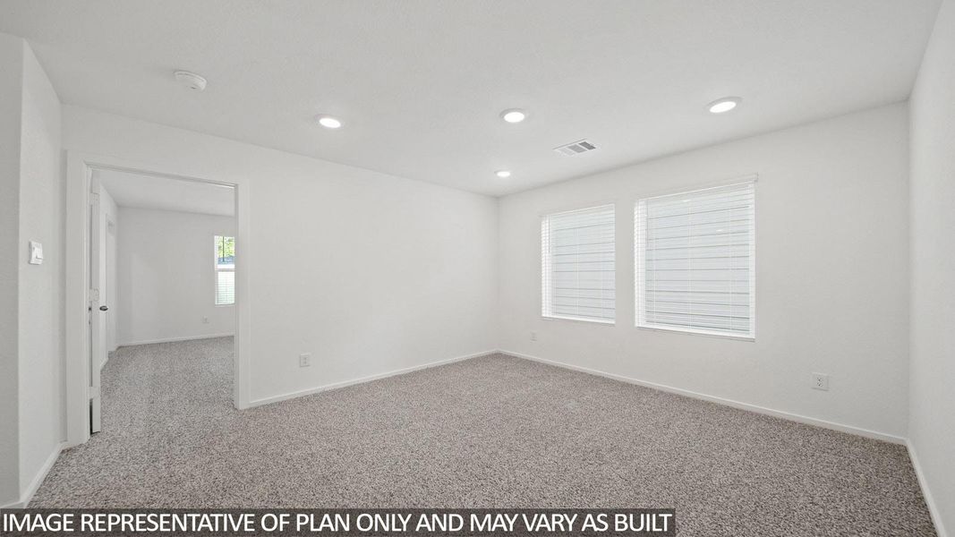 Carpeted room with recessed lighting, multiple windows featuring horizontal blinds, and a doorway opening into another carpeted room