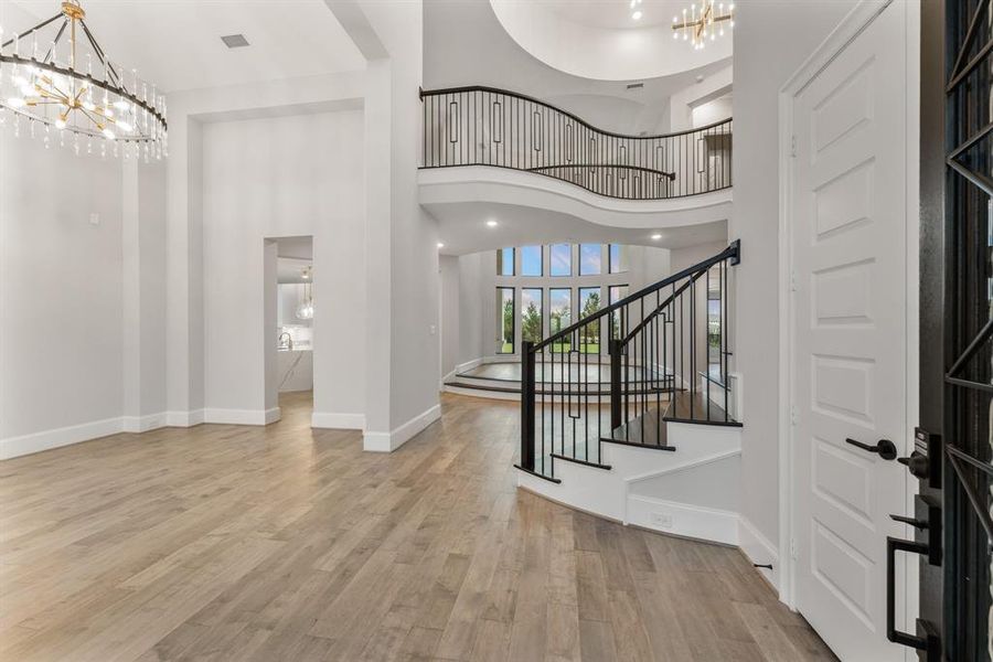 -- Representational Photo -- Grand Foyer view entering through the gorgeous double iron front doors with sites into the phenomenal Formal Dining Room, elevated two-story Living area, winding staircase and curved catwalk with lots of design appeal.