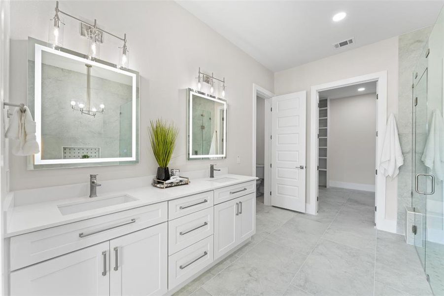 Bathroom with double vanity, a spacious closet, a shower stall, and recessed lighting Bathroom with double vanity, a spacious closet, a shower stall, and recessed lighting