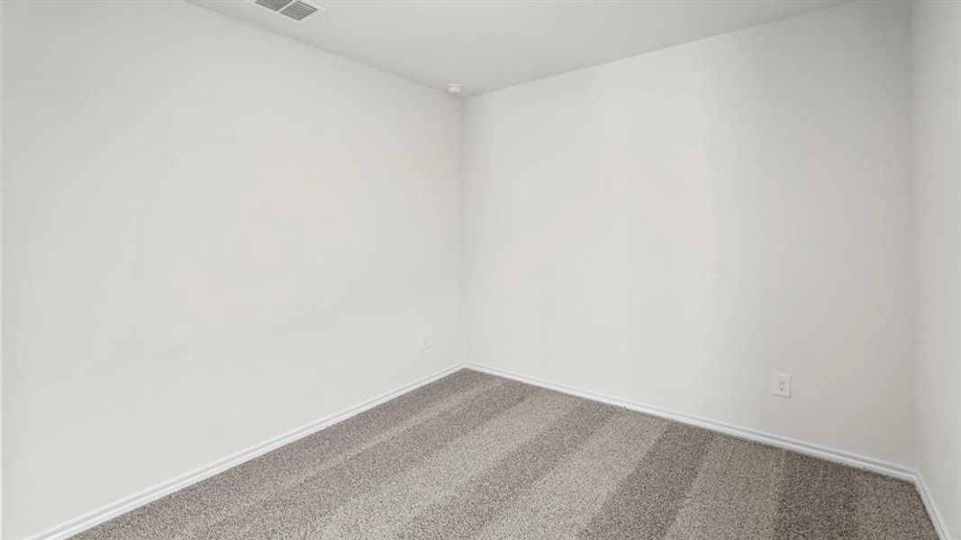 Light gray carpet flooring with visible vacuum lines, complemented by white baseboards and neutral white walls