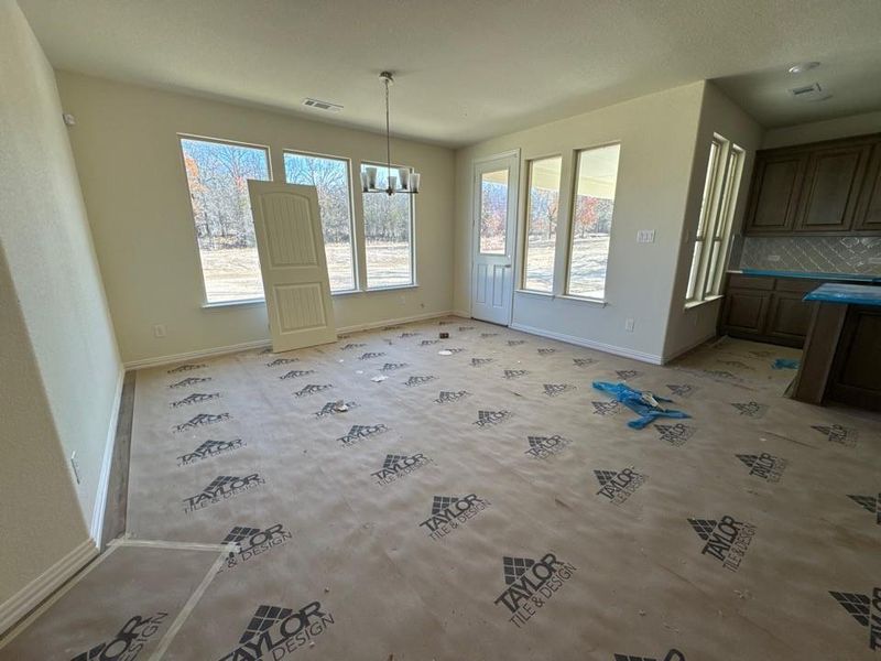 Unfurnished dining area featuring baseboards and a chandelier
