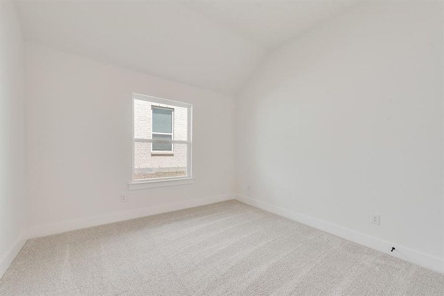 Empty room featuring carpet flooring and vaulted ceiling Empty room featuring carpet flooring and vaulted ceiling