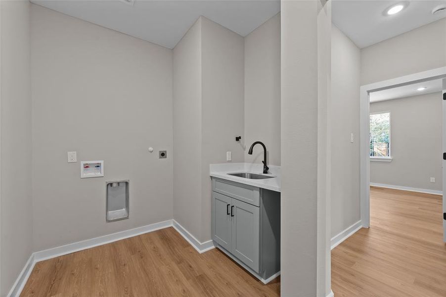 Large utility/laundry room with sink and additional panty/storage.