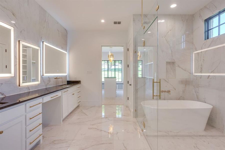 Bathroom featuring healthy amount of natural light, light marble finish flooring, double vanity, a marble finish shower, and recessed lighting