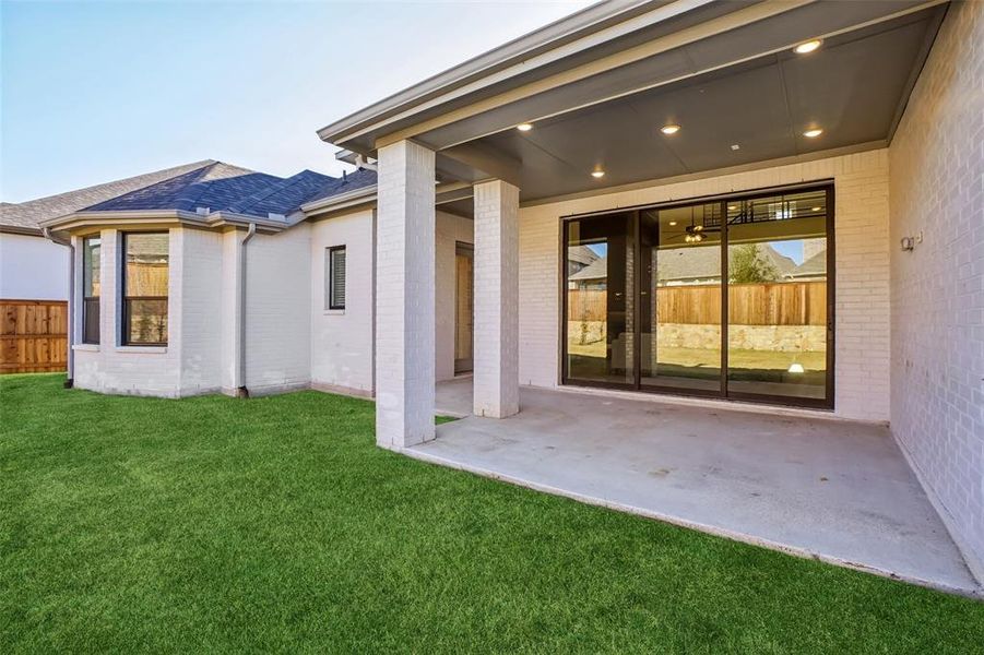 Back of property with brick siding, a patio, and a shingled roof Back of property with brick siding, a patio, and a shingled roof
