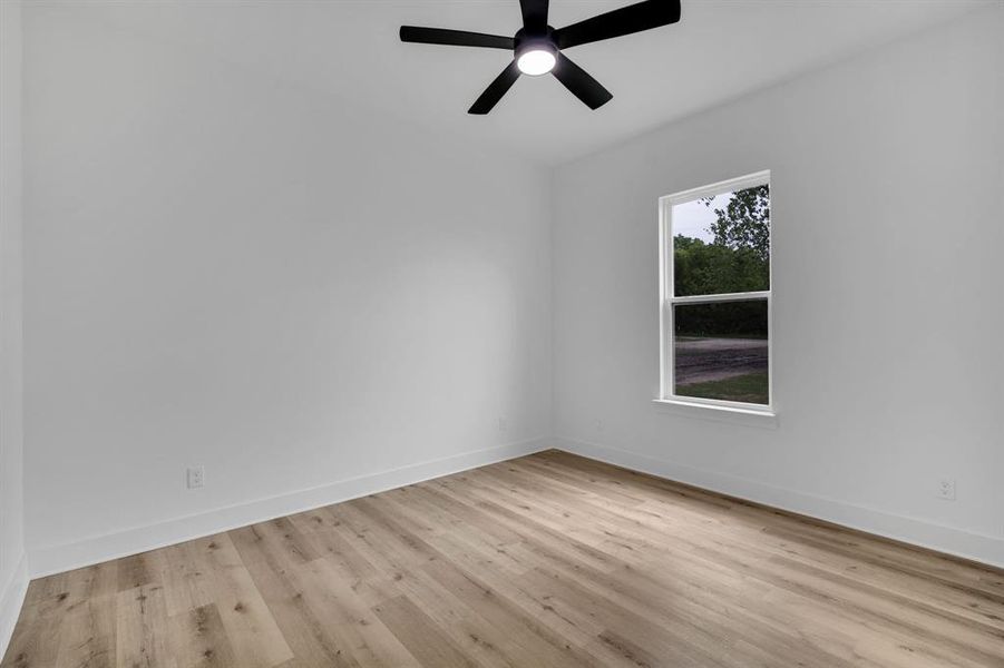 Empty room featuring ceiling fan and light hardwood / wood-style flooring