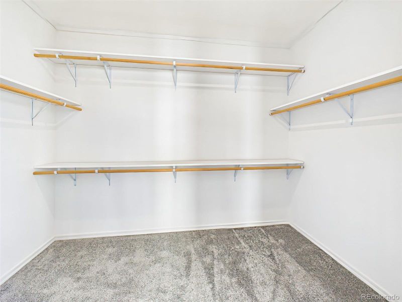 Generous walk-in closet with custom shelving and abundant storage. Generous walk-in closet with custom shelving and abundant storage.