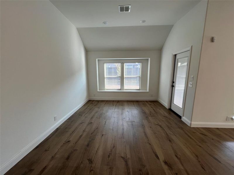Dining area featuring dark wood-type flooring, lofted ceiling, and recessed lighting. Dining area featuring dark wood-type flooring, lofted ceiling, and recessed lighting.