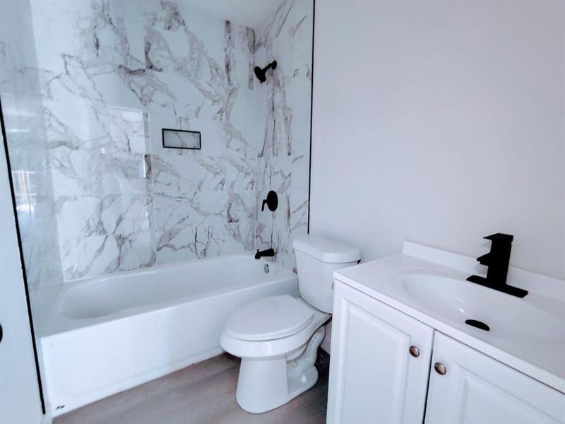 Full bath with vanity, shower / bathtub combination, and wood finished floors