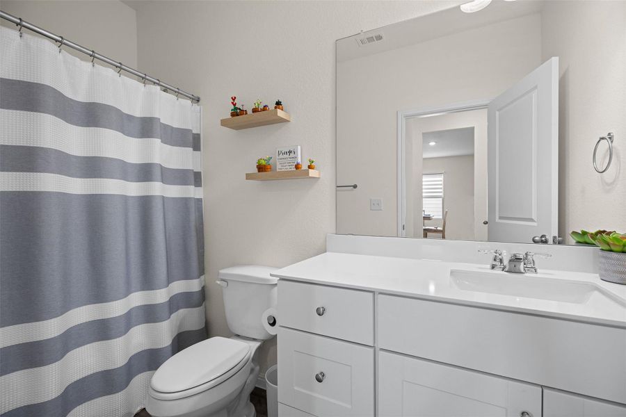 Full bath featuring a shower with curtain and vanity Full bath featuring a shower with curtain and vanity