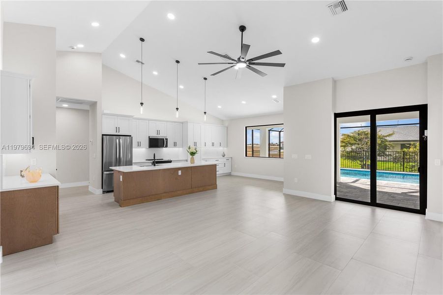IMPACT-RESISTANT DOUBLE DOORS lead into WELCOMING LIVING ROOM w/ 12-ft VAULTED CEILING & SLIDING DOORS TO LANAI. IMPACT-RESISTANT DOUBLE DOORS lead into WELCOMING LIVING ROOM w/ 12-ft VAULTED CEILING & SLIDING DOORS TO LANAI.