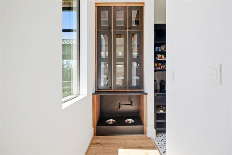 Additional storage with an adorable space for dog food and water off the pantry.