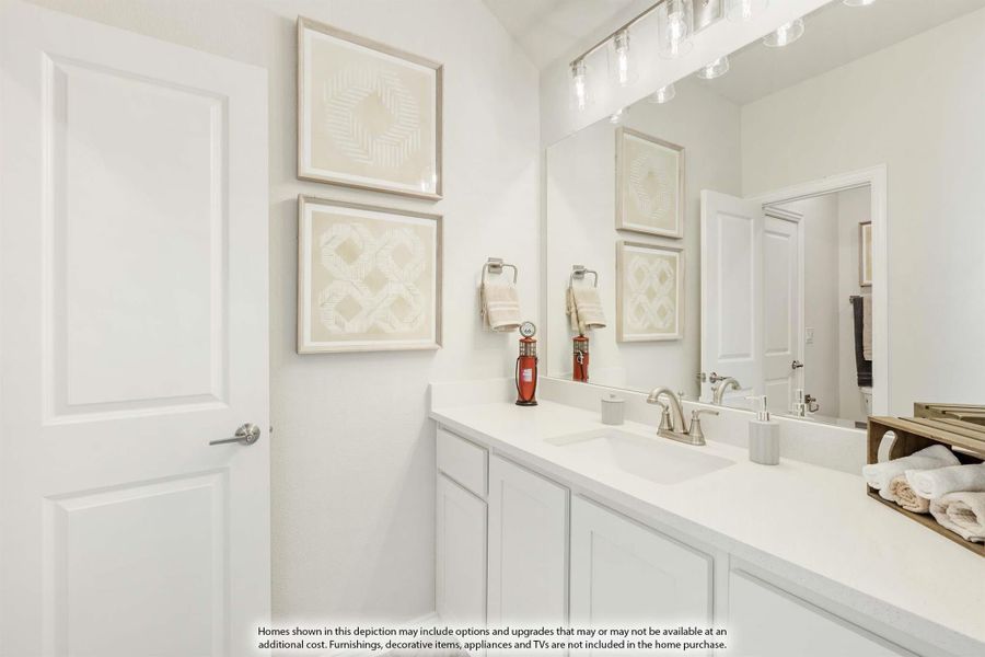 Bathroom with white vanity, single sink, large mirror, and wall art above the counter