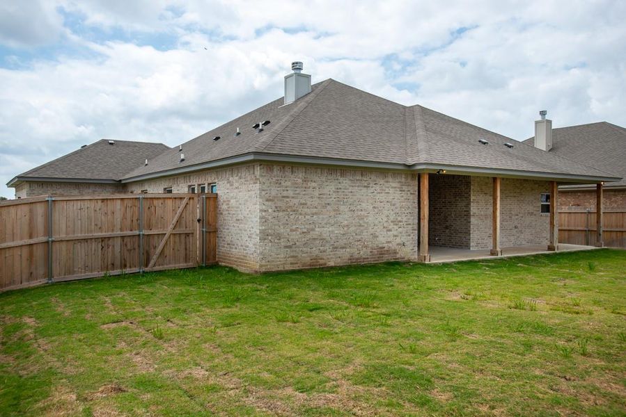 Back of property featuring a chimney, brick siding, a shingled roof, and a patio area Back of property featuring a chimney, brick siding, a shingled roof, and a patio area