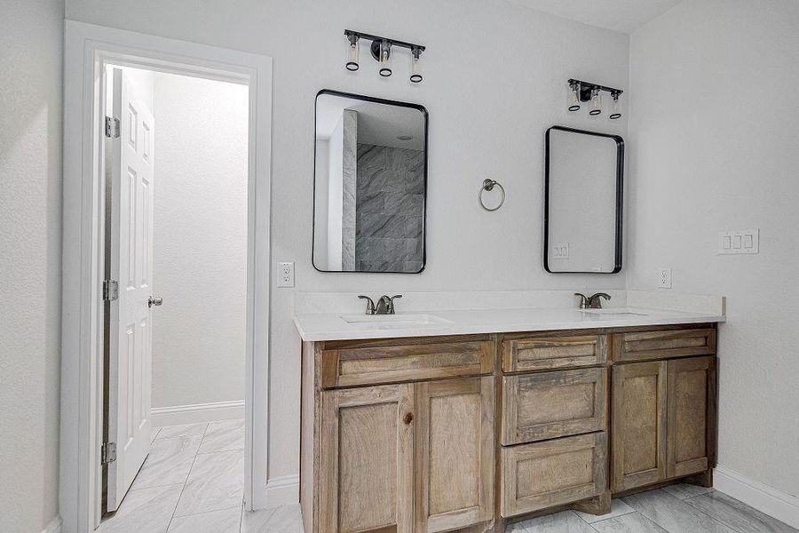 Bathroom with tile patterned floors and dual bowl vanity