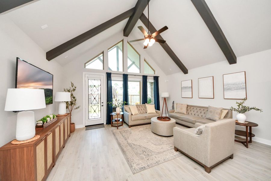 Vaulted family room with beam accents and wall of windows to the backyard.