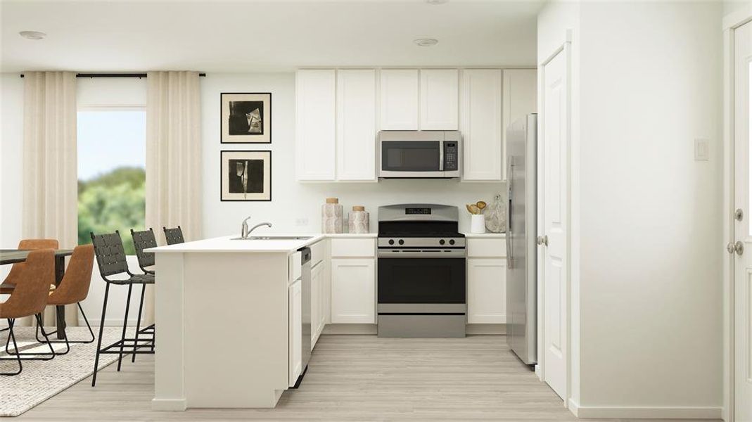 Modern kitchen featuring white cabinetry, light countertops, stainless steel appliances, and wood-finish flooring Modern kitchen featuring white cabinetry, light countertops, stainless steel appliances, and wood-finish flooring