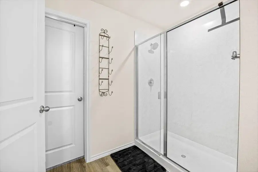 Walk-in shower featuring a sliding glass enclosure and white shower base Walk-in shower featuring a sliding glass enclosure and white shower base
