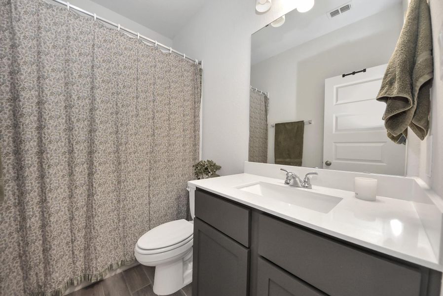 Experience modern sophistication in this bright, airy bathroom. Featuring a sleek vanity with a crisp white countertop, elegant fixtures, and subtle decorative touches, the space balances functionality with refined, spa-like comfort.