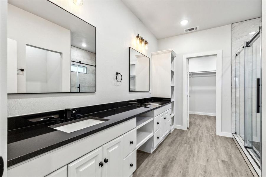 Primary Bathroom with vanity, hardwood / wood-style flooring, and walk in shower