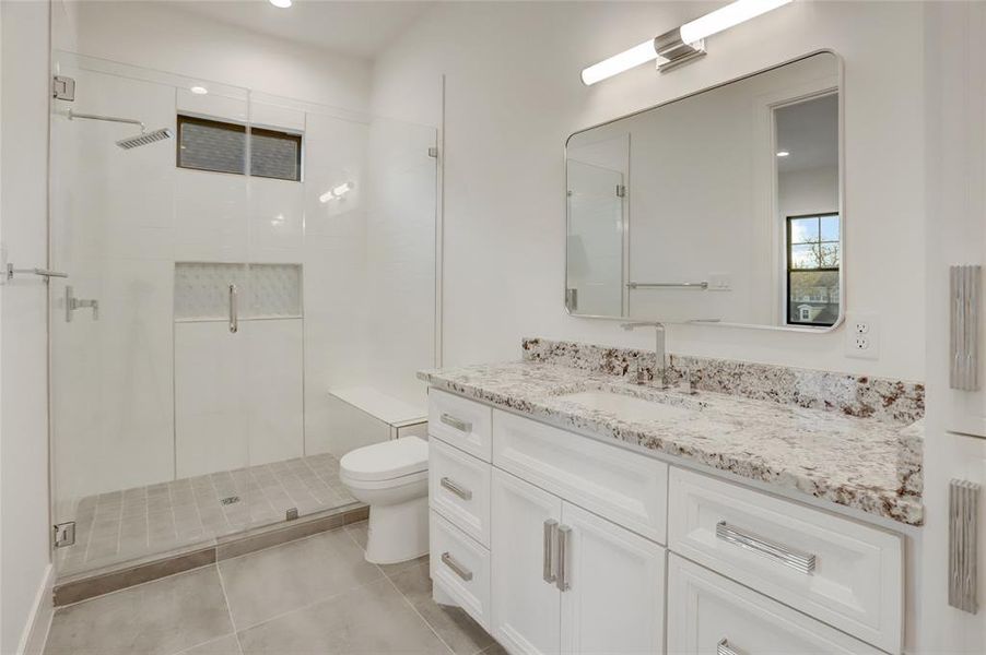 BATH #2: Walk-in oversize shower, 3 CM stone counters and striking accent tile and shampoo caddy.