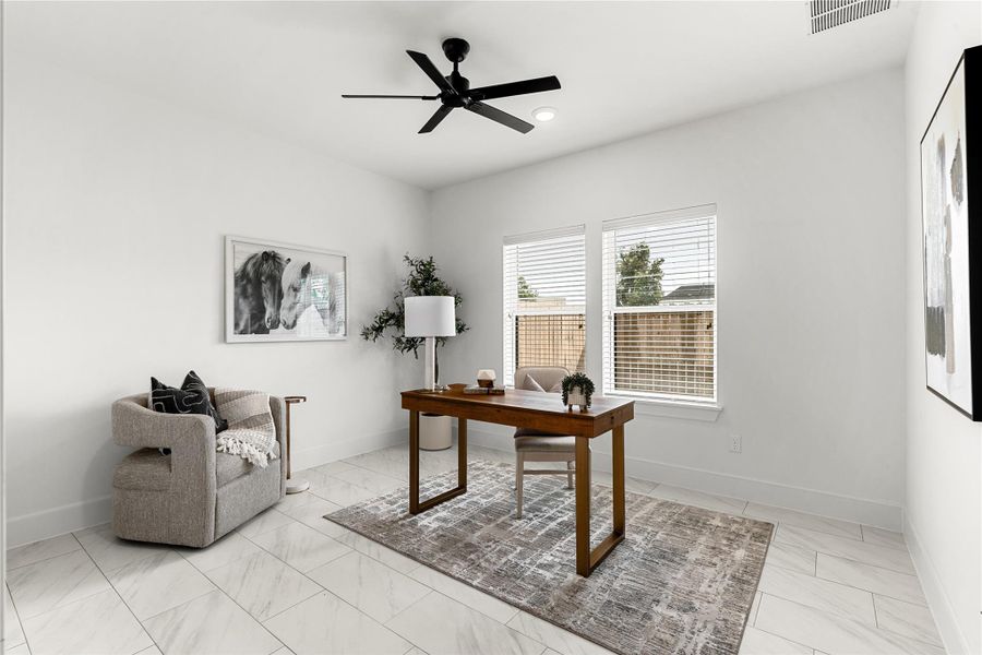 Modern office space featuring white walls, large windows, and a ceiling fan.