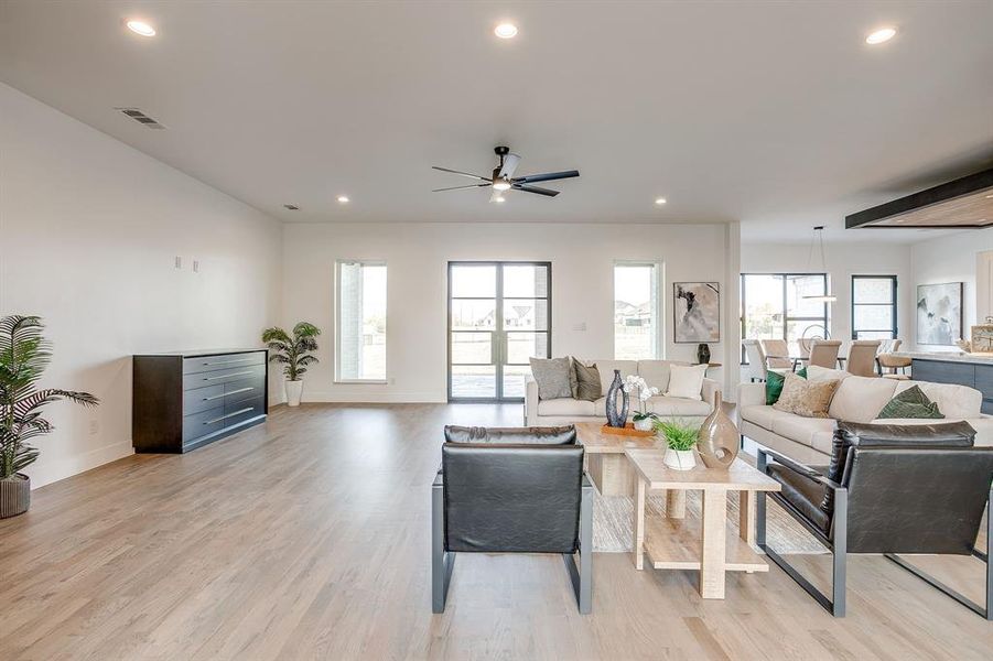 Living area with recessed lighting, plenty of natural light, light wood-style floors, and ceiling fan Living area with recessed lighting, plenty of natural light, light wood-style floors, and ceiling fan