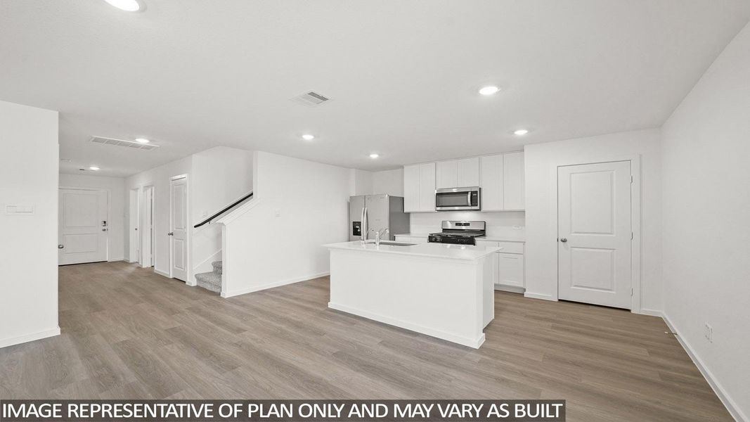 A well-lit open-concept kitchen and living area showcases an inviting atmosphere with contemporary finishes.