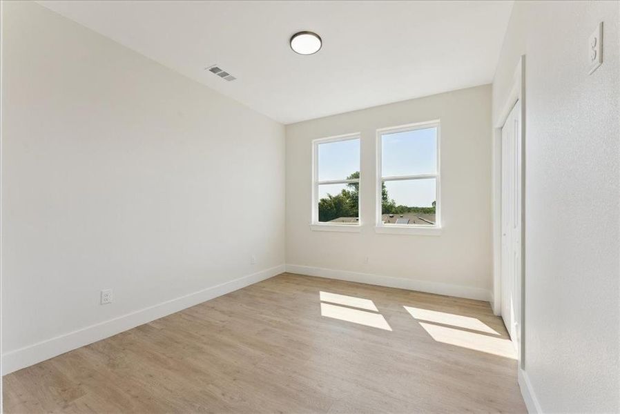 Spare room with baseboards and light wood-style flooring