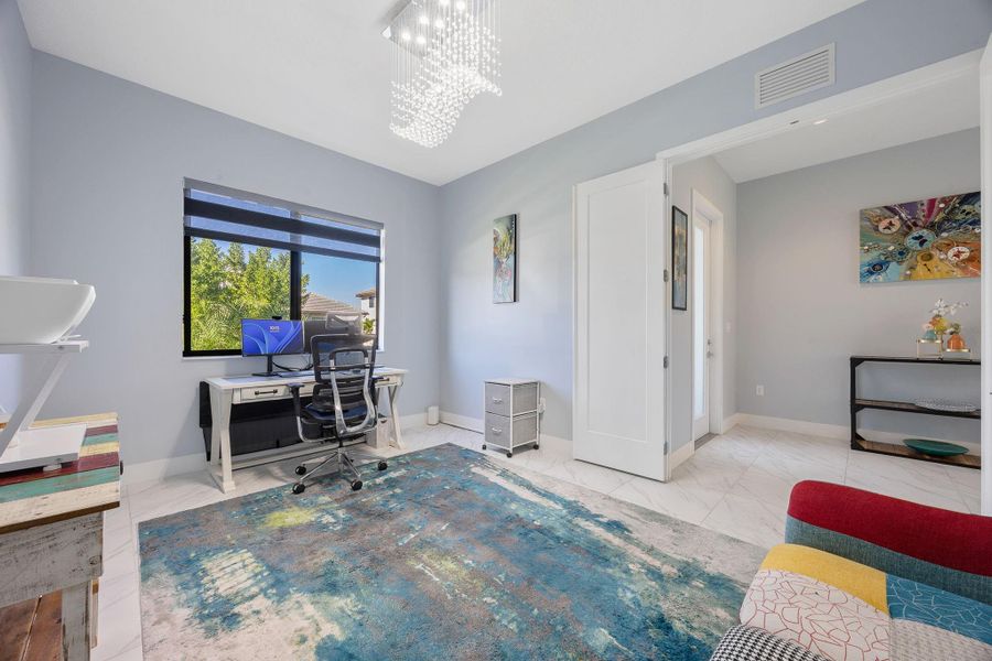 Office with a chandelier and light marble finish flooring