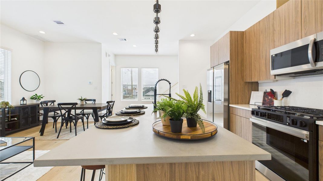 The heart of the second-floor open-concept living, dining, and kitchen, this spacious kitchen island features sleek modern finishes, including a one-sided cascade quartz countertop, a farmhouse sink, and stylish pendant lighting, with a built-in seating area perfect for casual breakfasts or chatting with family and friends.