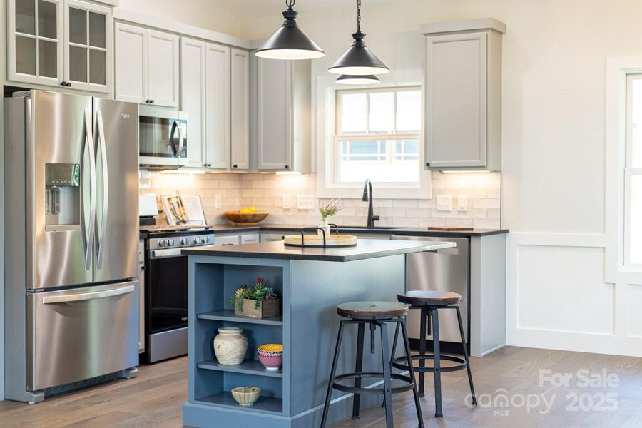 The kitchen features custom cabinetry, solid surface countertops, and Energy Star stainless appliances.