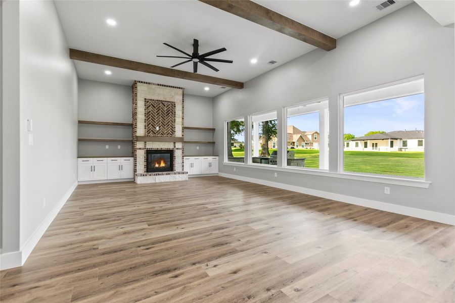 The large and open living area features a gas log fireplace, media storage, wood beams and a peaceful view of the large backyard. The large and open living area features a gas log fireplace, media storage, wood beams and a peaceful view of the large backyard.