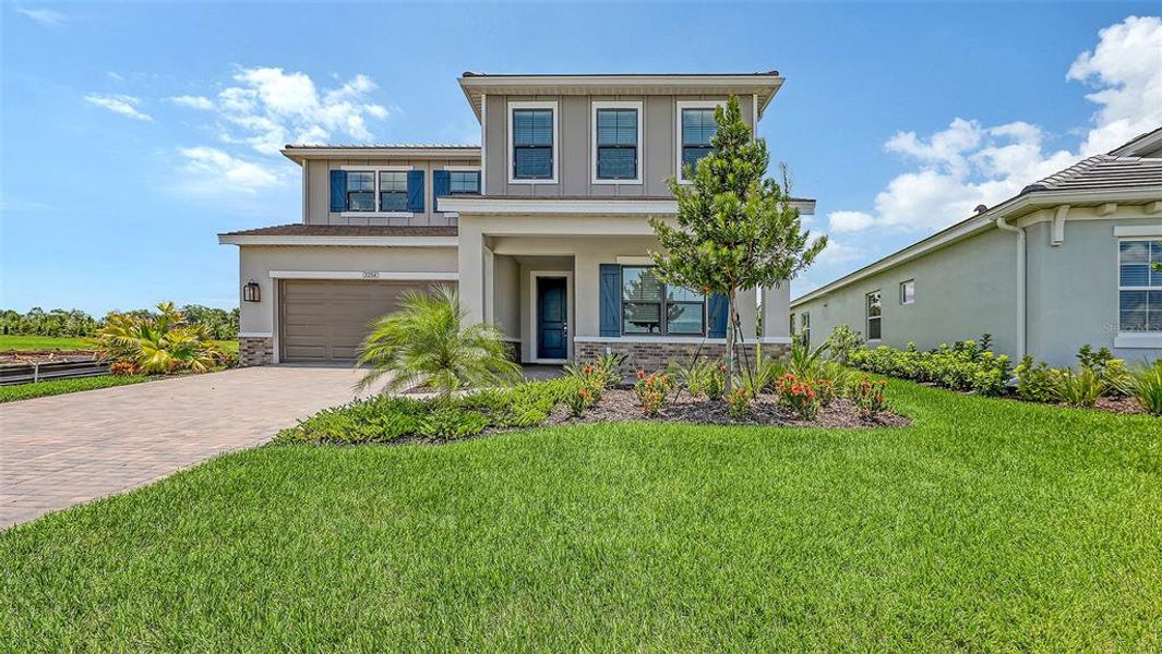 Front exterior of a new home in Palm Grove, Lakewood Ranch, FL, highlighting curb appeal (Image 21). Front exterior of a new home in Palm Grove, Lakewood Ranch, FL, highlighting curb appeal (Image 21).