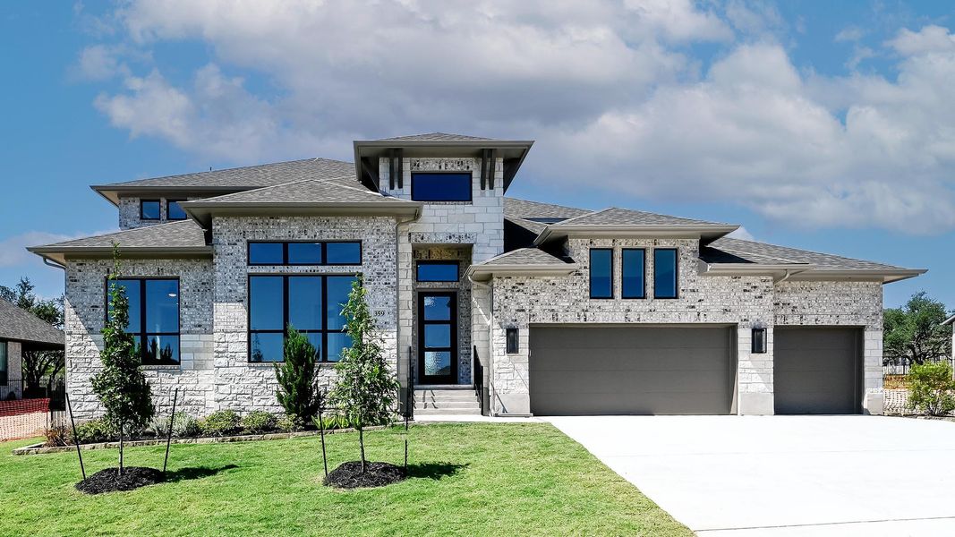 View of front of home featuring a shingled roof, driveway, a front lawn, and stone siding View of front of home featuring a shingled roof, driveway, a front lawn, and stone siding