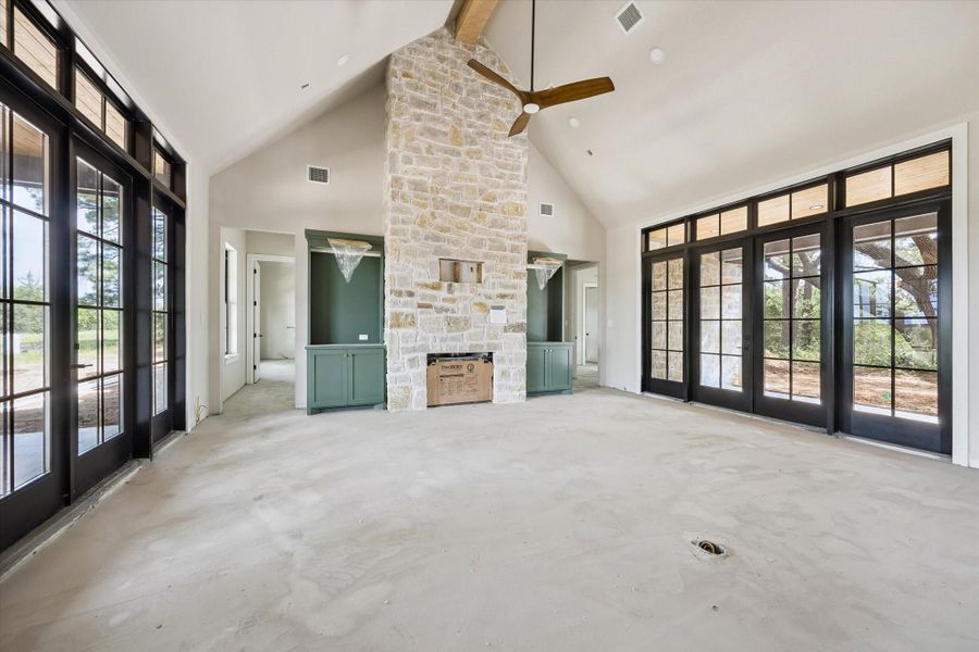Stone on fireplace to ceiling with built-ins with lighting on either side.