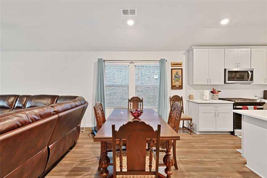 Dining space with recessed lighting, visible vents, and light wood-style flooring