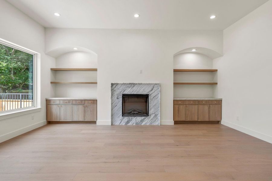 Spacious living room for entertainment and beautiful arches with custom cabinetry.