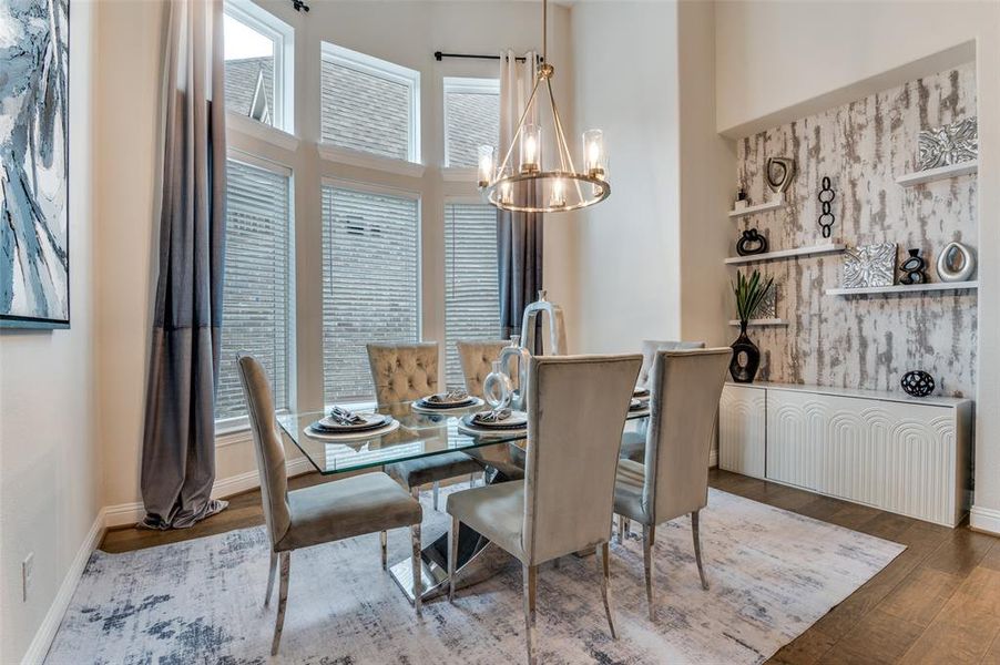 Dining room featuring a chandelier, a towering ceiling, and wood finished floors