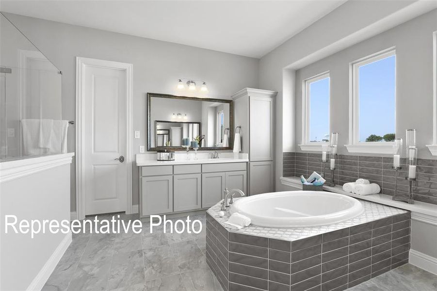 Bathroom with tile flooring, large vanity, and tiled bath