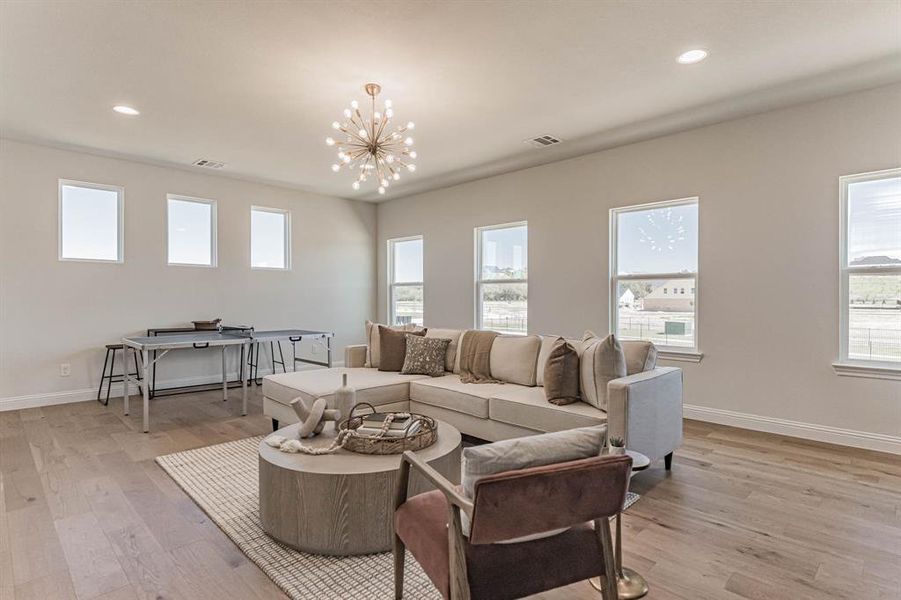 Living room featuring light hardwood / wood-style floors, plenty of natural light, and a chandelier