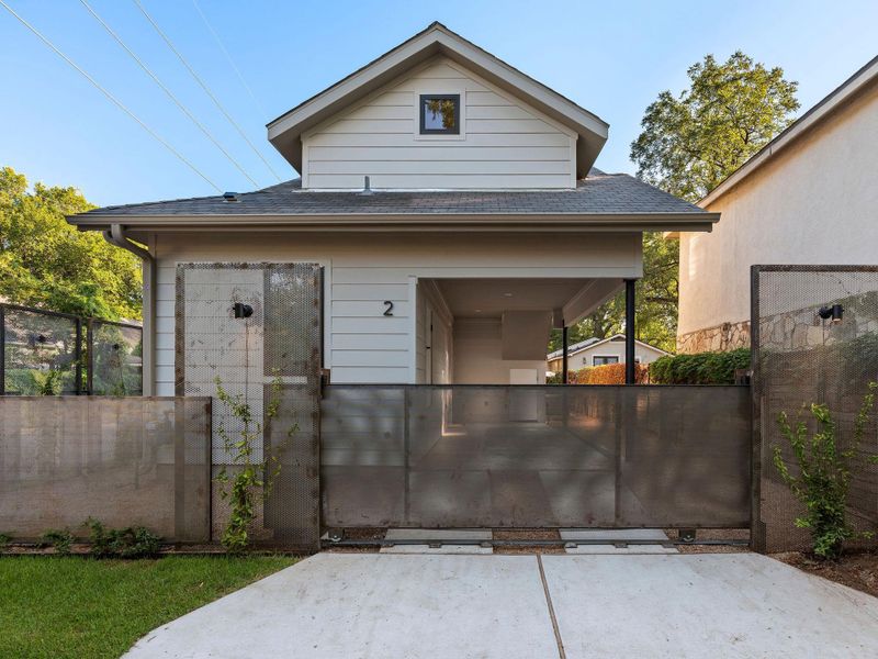 View of front facade featuring roof with shingles and a gate View of front facade featuring roof with shingles and a gate