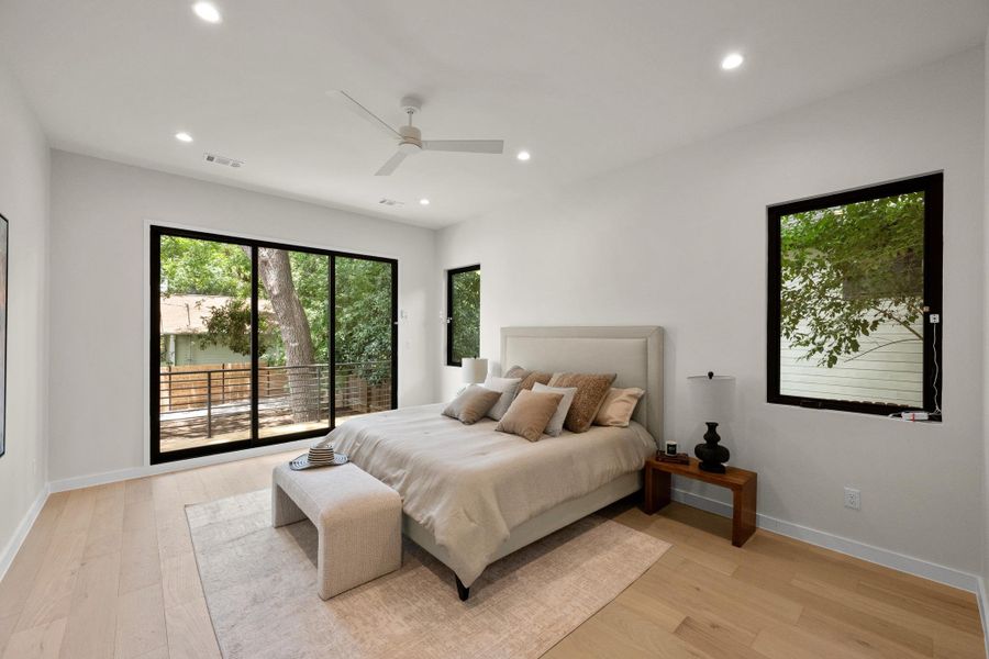 Hardwood flooring and recessed lighting illuminate this serene primary bedroom. Hardwood flooring and recessed lighting illuminate this serene primary bedroom.