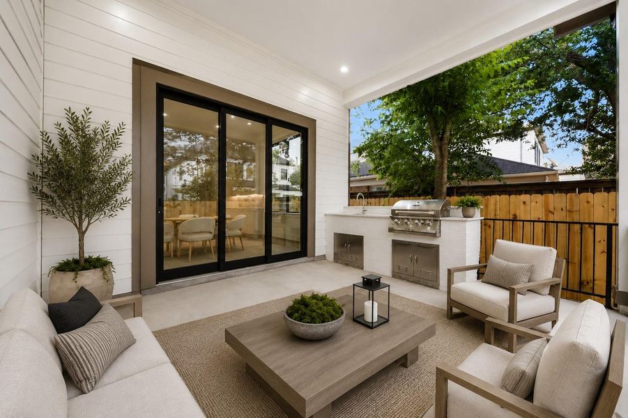 Covered outdoor patio with grill, sink and built in storage cabinets
